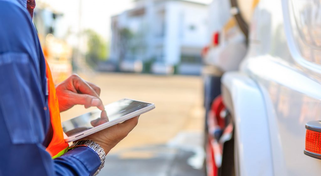 Truck drivers hand holding tablet checking the product